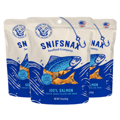 Three packages of Snifsnax Seafood Company 100% Salmon freeze-dried fillets for dogs on a white background.